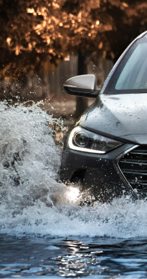 Car driving on flooded roadway