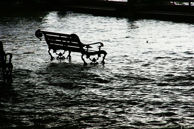 Picture of park bench partial submerged by flood waters